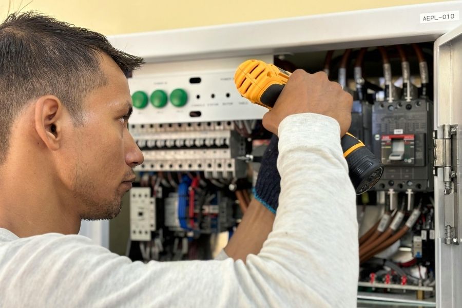 A man is working on an electrical panel