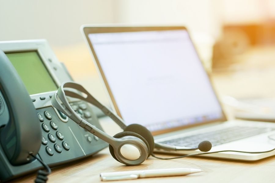close up focus on call center headset device at telephone VOIP system at office desk for hotline telemarketing concept with vintage color filter